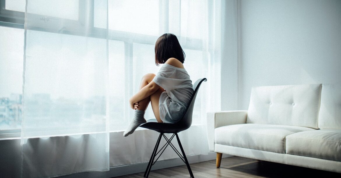 woman sitting on black chair in front of glass-panel