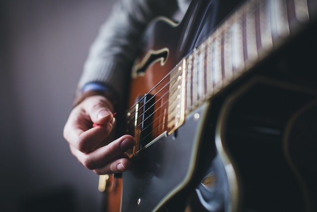 person playing on guitar