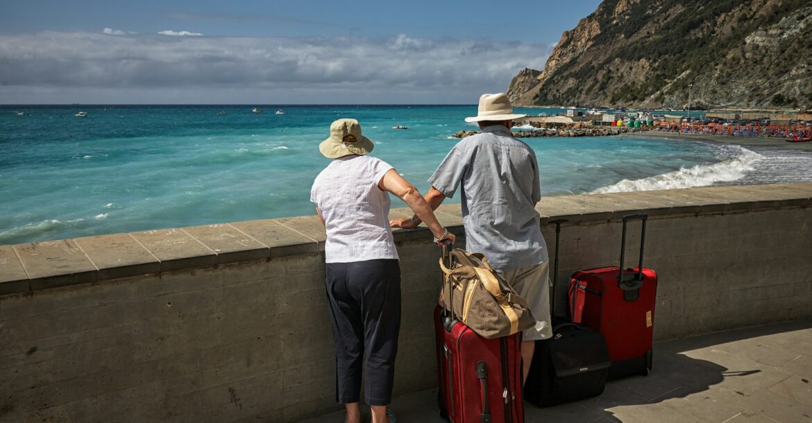 man-and-woman-standing-beside-concrete-seawall-looking-at-beach