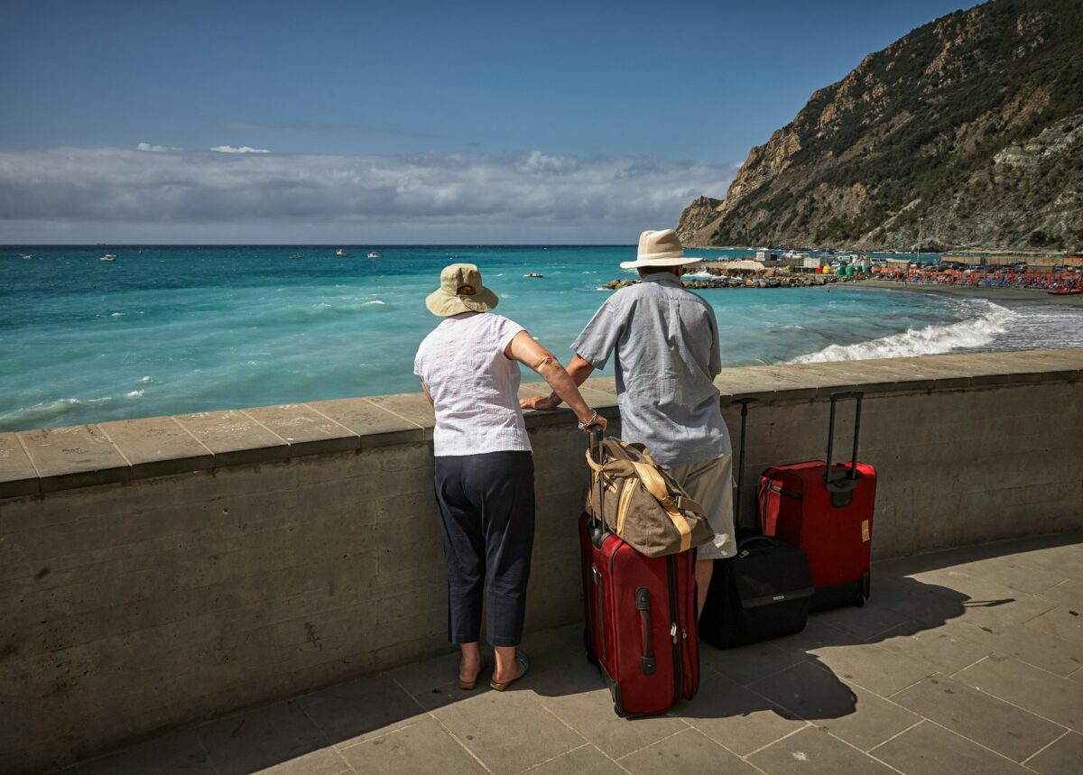 man-and-woman-standing-beside-concrete-seawall-looking-at-beach