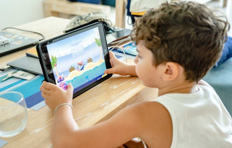 a-boy-in-white-tank-top-playing-on-a-tablet
