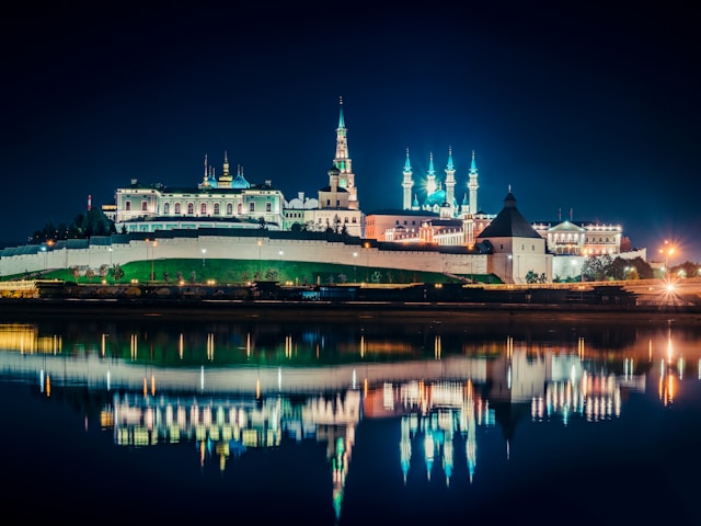 a-large-building-with-a-clock-tower-next-to-a-body-of-water